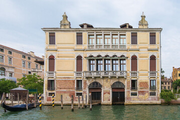 Distressed brick Venetian palace facade with yellow plaster