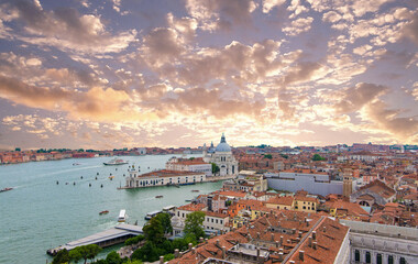 Panoramic Venice cityscape with red tiled roofs and basilica at sunset