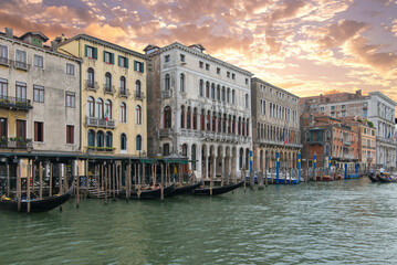 Black gondolas near historic Venice palazzos at golden sunset