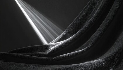 어두운 공간 속에서 강렬한 한 줄기 빛이 부드럽게 주름진 검은색 벨벳 질감의 천 위로 쏟아지며 극적인 명암 대비와 신비롭고 우아한 분위기를 연출하는 예술적인 흑백 추상 배경 이미지.