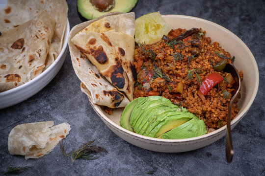 Pland based protein bowl consisting of pepper, eggplant and millet pilaf, avocado, tortilla