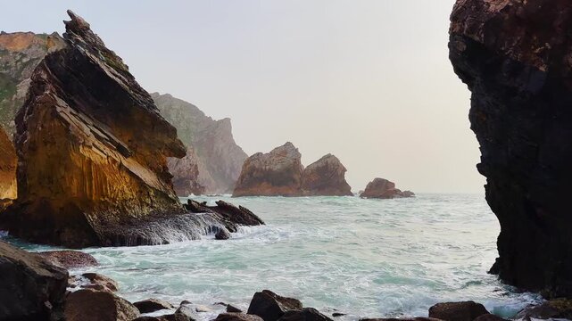 Beautiful rocky coast beside the Atlantic. The popular Portuguese Ursa Beach. Beautiful panoramic view of the rocky shore with incoming blue waves. Beautiful ocean against a background of rocks.