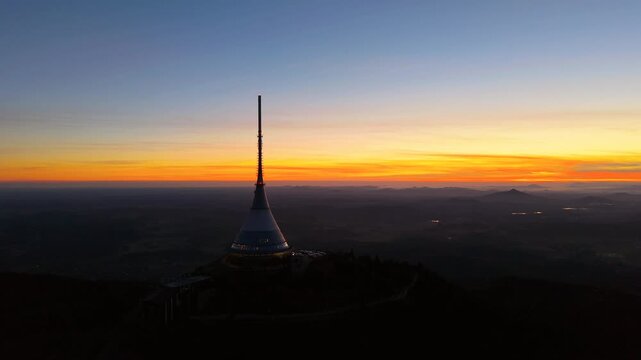 Jested Mountain shows a sunset over Czechia. The transmitter stands tall while the sky changes colors. Viewers can enjoy this beautiful moment from the height of the mountain.