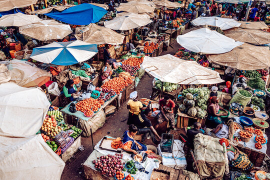Kampala, Uganda - 28 March 2024: View of a bustling marketplace under a canopy of umbrellas, vibrant with colorful produce and the lively energy of traders and customers..