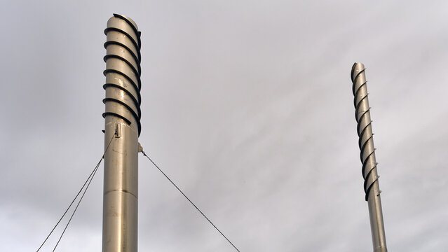 Nymolla, Sweden - 21 September 2025: View of towering chimney structures spiral skyward, their sleek surfaces reflecting the muted tones of the overcast sky.