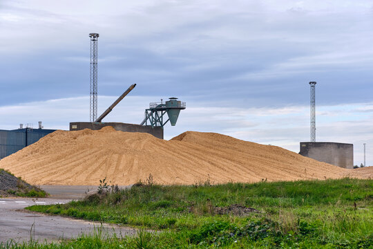 Nymolla, Sweden - 21 September 2025: View of Sylvamo Nymolla Mill, where a vast mound of wood chips contrasts against the industrial backdrop under a muted sky.