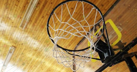 Naklejka premium Showing basketball hoop assembly hanging from gym ceiling, featuring black rim white net yellow pad