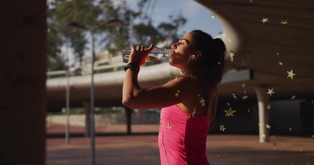 Drinking woman in pink tank top pausing workout at urban plaza under pavilion, holding water bottle © vectorfusionart