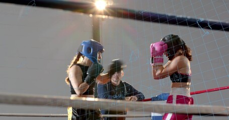 Facing two female fighters, coach wearing dark top leaning on ropes in ring, headgear and gloves
