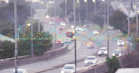 Fototapeta premium Showing urban highway carrying cars moving with light bokeh, concrete median, overlaying waveform