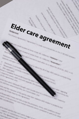 Elder care agreement contract on desk, legal document for senior caregiving services, family support and healthcare responsibility concept.