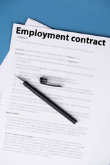 Employment contract document on office desk, legal agreement for hiring, job offer, and professional business relationship concept.