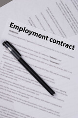 Employment contract document on office desk, legal agreement for hiring, job offer, and professional business relationship concept.
