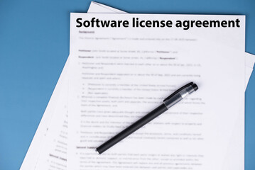 Obraz premium Software license agreement document on office desk, legal contract granting rights to use software under specific terms, symbol of digital compliance, intellectual property, and business technology.