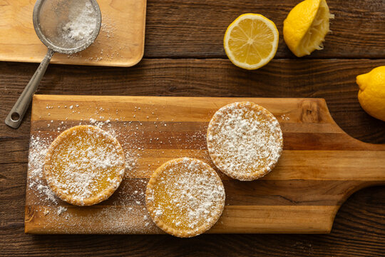Overhead shot of lemon tarts  on dark wood