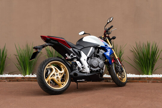 Tricolor Honda CB1000R rear three quarters view, Naked sport bike parked on brown sidewalk