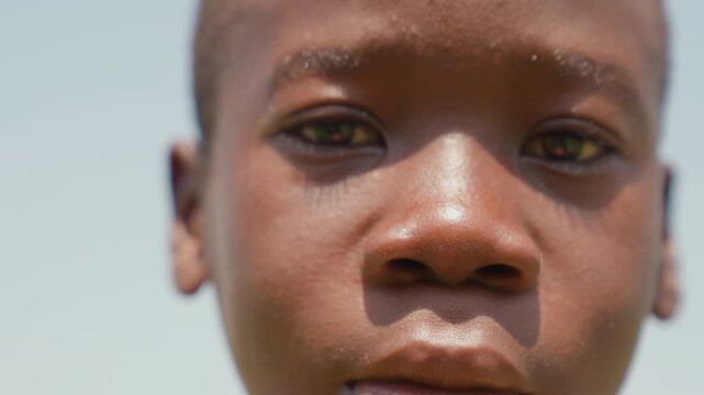 Black boy intense closeup sweating skin and focused eyes, detailed texture and sunlight reveal grit and emotion, intimate portrait of determination, raw honesty and athletic resolve