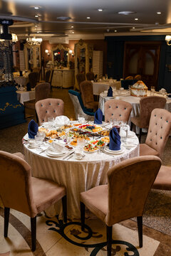 Kazakh national dastarkhan on round banquet table with traditional decor