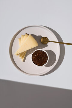 Manchego cheese with fig jam on white plate
