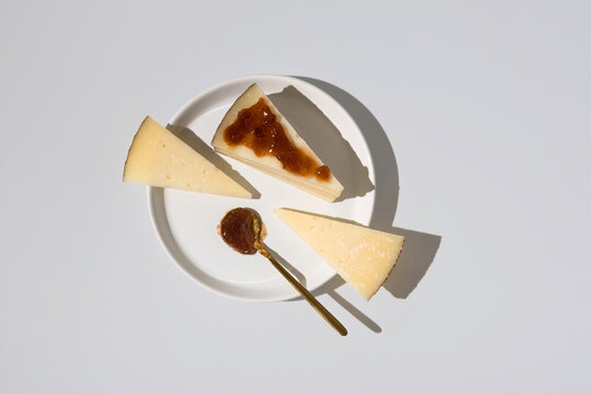 Manchego cheese with fig jam on white plate