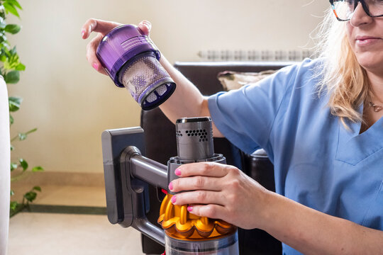 Woman cleaning vacuum with attention to detail