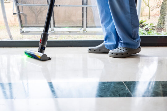 Woman cleaning house with modern vacuum cleaner