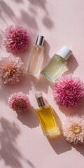 Elegant floral fragrance bottles with pink flowers on light pink background