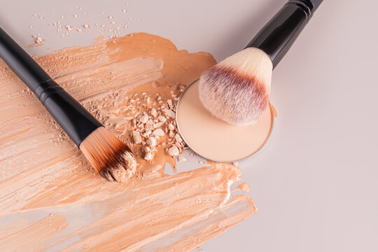 Face powder and brushes on a textured background