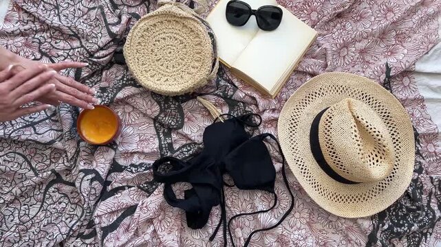 Manos de mujer aplicando bronceador en flat lay playero