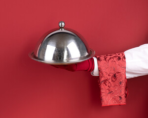 Waiter's hand with a tray isolated on a red background