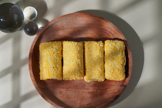 Top view of Risol Pastry Snack served on a wooden plate with abstract lighting