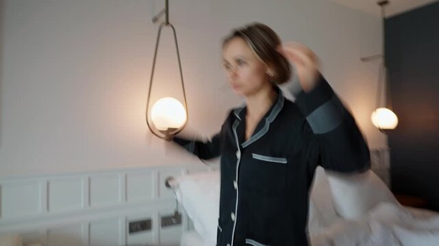 Woman standing in a modern room after waking up, holding her head as she experiences dizziness. Wearing pajamas, she appears disoriented and slightly unwell, suggesting fatigue, jet lag, headache, or