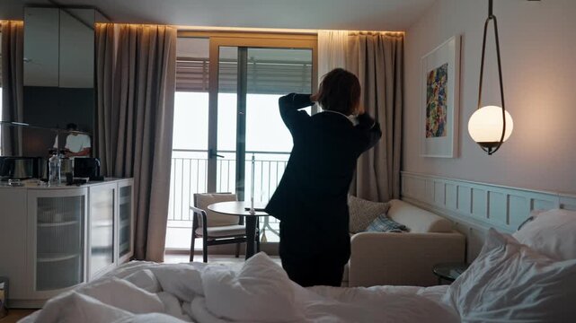 Woman standing in a modern room after waking up, holding her head as she experiences dizziness. Wearing pajamas, she appears disoriented and slightly unwell, suggesting fatigue, jet lag, headache, or