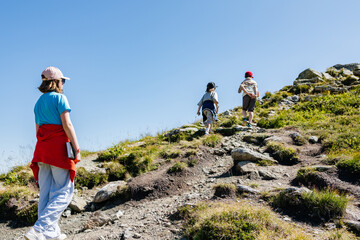 Fototapeta premium Children hiking up a mountain trail on a sunny day