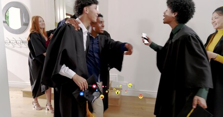 Greeting graduating students in black gowns, sharing mortarboards and smartphone reactions in foyer