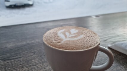 Barista creates latte art with heart design on coffee in cafe