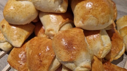 Freshly baked bread rolls on wooden skewers on a table