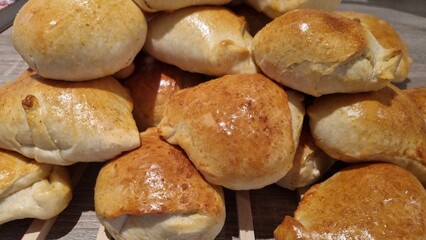 Freshly baked bread rolls on a wooden surface ready for serving at a gathering