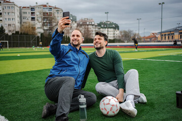 Friends taking selfie on soccer field after training © Jelena