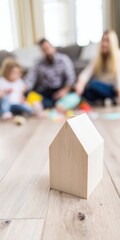 Wooden house model with family playing in background