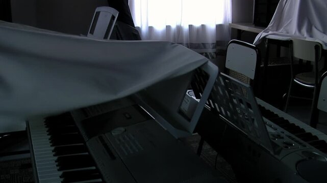 Uncovering Electronic Keyboards in School Classroom, Digital Pianos Under White Cloth 