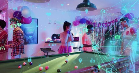 Playing guests in festive outfits around green-felt pool table at party room, with cues, AR overlay