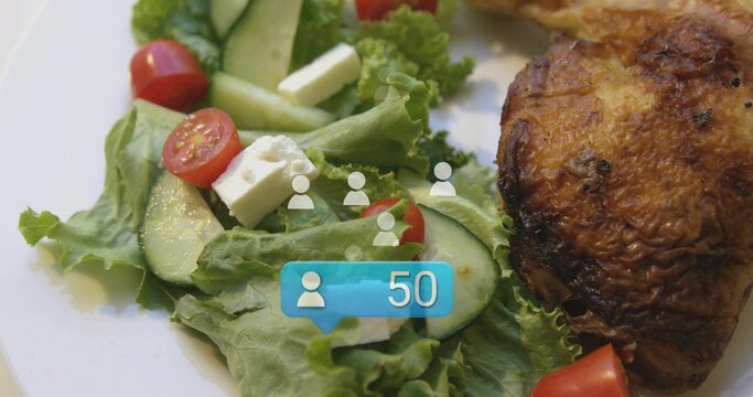 Showing white plate with lettuce, cucumber, tomatoes, feta cubes and roast thigh on table, badge 50