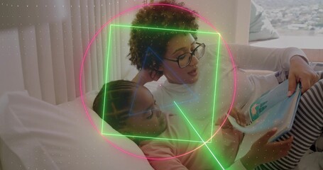 Reading mom-daughter lying on bed by blinds, with specs, striped-leggings, blue book, neon overlays