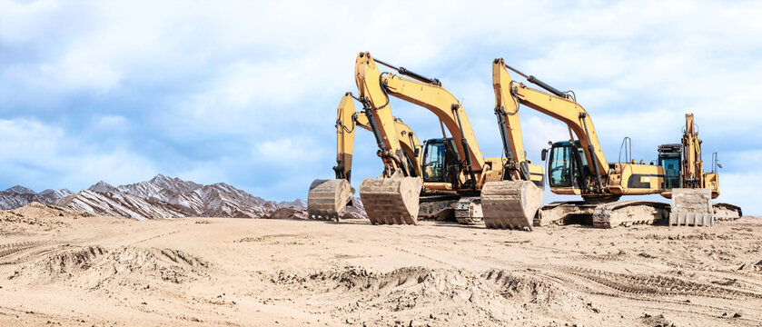 A fleet of powerful excavators is ready to tackle a major construction project. Construction equipment rental