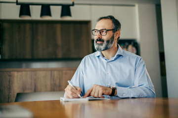 Business man thinking, writing notes at home office