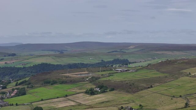 aerial high panning view of of midgley moor showing the village of old town and high moorland landscape