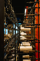 Machine industrielle tenant des bobines de fil © Concept Photo Studio