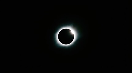 Total solar eclipse with diamond ring effect. Bright sun flare and corona in dark sky. Astronomical celestial event