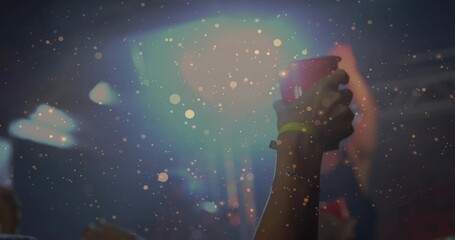 Naklejka premium Raising female arm holding red cup with neon wristband and bracelet at concert, copy space